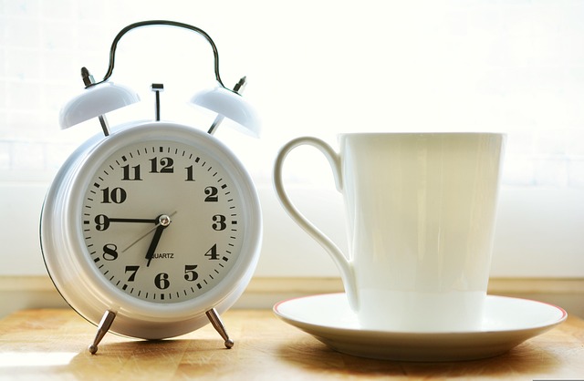 Person using a wake-up light alarm clock that simulates sunrise for better morning routine